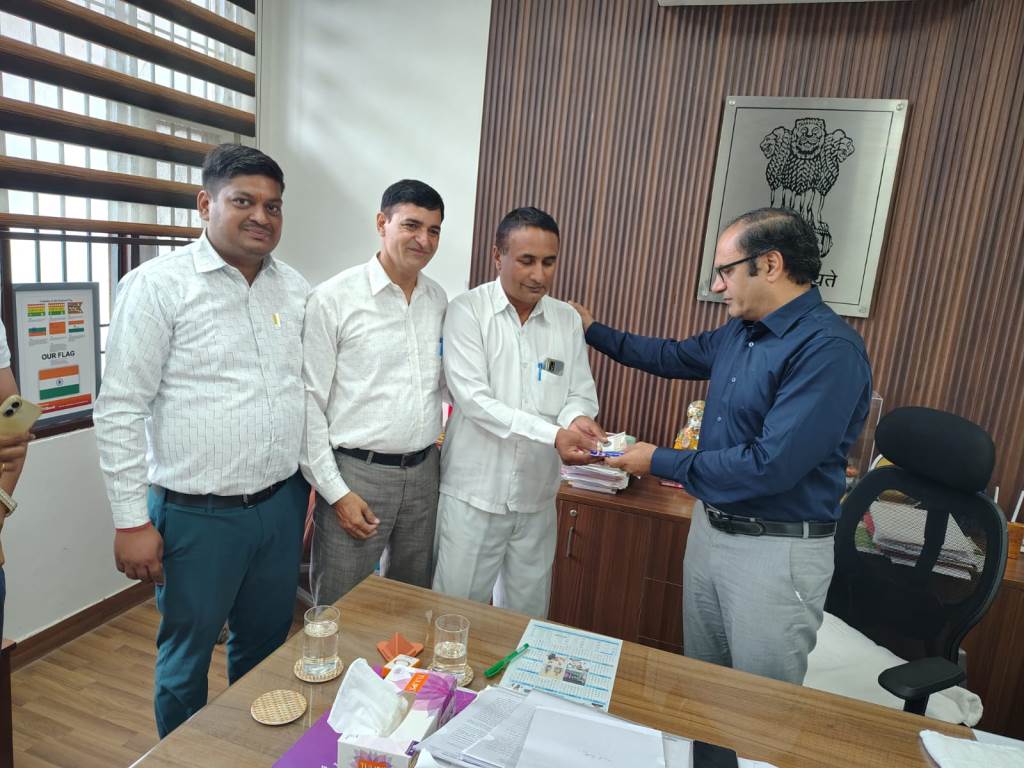 SDM Rajesh Khoth honors Booth Level Officer Rampal with a certificate of appreciation and cash prize for excellent work in the SSR campaign